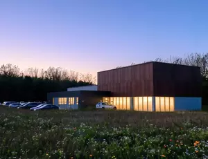 Moderne forsyningsbygning i skumringen, der illustrerer sikker drift og beredskab ved strømsvigt.